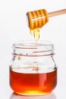 Honey trickling into a glass — Stock Photo