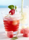 Pugno con lamponi e melone di rugiada al miele servito con cubetti di ghiaccio rosa — Foto stock