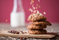 Homemade oatmeal cookies with dried berries and falling oatmeal flakes — Stock Photo