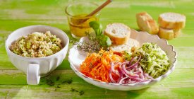 Салат из киноа с тертыми овощами, ломтиками багета и винегретом — стоковое фото