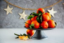 Ripe tangerines citrus fruits with leaves and Christmas decor — Stock Photo