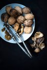 A plate of walnuts with a nut cracker — Stock Photo