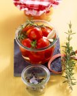 Tomates cherry en vinagre en escabeche con hierbas frescas y ajo - foto de stock