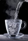 Boiling water being poured into a glass cup — Foto stock