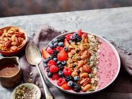 Tazón de desayuno con arándanos, moras, fresas, nueces y granola - foto de stock
