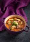 Beef and bean soup on purple background — Stock Photo