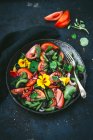 Salada de tomate e feijão com flores em uma tigela cinza — Fotografia de Stock