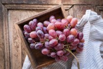 Red grapes in wooden crate with cloth — Stock Photo
