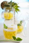 Ananaspunsch in Gläsern mit Minze auf dem Tisch — Stockfoto