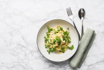Tagliatelle with peas and a creamy sauce — Stock Photo