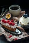 Еклер з ягодами і вершками, і ванільний кекс, чорна кава — стокове фото