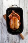 Roast chicken in a black dish — Stock Photo