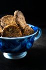 Пряное печенье с грецкими орехами, финики и кокосовые хлопья в синей чашке — стоковое фото