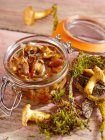 Funghi di finferli raccolti in aceto con aglio, erbe e spezie — Foto stock