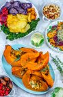 Vegan food, baked pumpkin with sage, germinated seeds and chips from two kinds of potatoes, pumpkin, beetroot and kale, dried fruits and nuts — Stock Photo