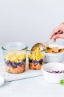 Close-up shot of delicious Layered Mexican salads in jars — Stock Photo