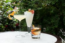 Набір з трьох коктейлів на столі в саду — стокове фото