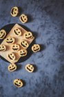 Biscoitos em forma de abóbora de Halloween na placa e superfície rústica — Fotografia de Stock