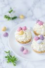 Cupcakes with creamy frosting and sugar eggs for Easter — Stock Photo