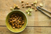 Freshly harvested hazelnuts in a bowl and next to it — Stock Photo