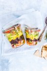 Close-up shot of delicious Layered Mexican salads in jars — Stock Photo