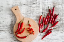 Red chili peppers, whole and cut — Stock Photo