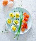 Stuffed eggs with chives and cherry tomatoes — Stock Photo