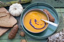 Autumnal pumpkin soup on green wooden table — Stock Photo