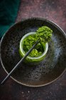 Grünes Pesto in einem Glas dunklen Hintergrund — Stockfoto