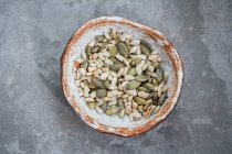 Roasted pumpkin and sunflower seeds in a hand made bowl — Stock Photo