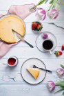 Caffè servito con torta di formaggio vegana, frutta fresca, salsa di fragole e tulipani — Foto stock