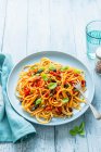 Spaghetti Puttanesca con olive, capperi, pomodori, scaglie di peperoncino e basilico fresco — Foto stock