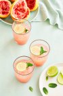 Pink Grapefruit and Mint cocktails with limes — Stock Photo