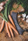 Zanahorias, cebollas, champiñones y un cuchillo para picar - foto de stock