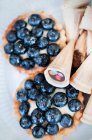 Blueberry tartlets and ice cream cones — Stock Photo