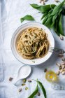 Wholemeal spaghetti with wild garlic and pistachio nut pesto and almond cheese substitute (vegan) — Stock Photo