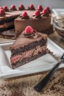 Scheibe Schokolade-Himbeermousse-Kuchen auf quadratischem weißen Teller — Stockfoto