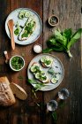 Bread with wild garlic pesto, cream cheese and cucumber on a wooden background — Stock Photo