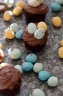 Шоколадні кекси з міні-шоколадними яйцями на текстурованій поверхні — стокове фото