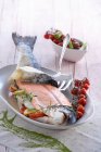 Whole salmon with cherry tomatoes and rosemary — Stock Photo