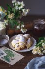 Hausgemachte Croissants mit Blumen und Honig auf einem hölzernen Hintergrund — Stockfoto
