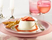 Erdbeer-Panna-Cotta mit Filoteig-Twist und Coulis mit einem Glas Rosenwein — Stockfoto