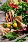 Un arreglo de verduras con remolacha, calabaza, zanahorias coloridas, tomates y mizuna - foto de stock
