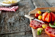 Various heirloom tomatoes with salt, pepper and basil — Stock Photo