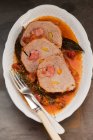 Stuffed pork roulade in a vegetable stock — Stock Photo