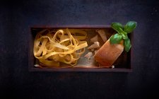 Papardelle com queijo parmesão e manjericão em uma caixa de madeira — Fotografia de Stock