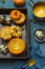 Pumpkin soup with rosmary and yogurt in small pumpkins, toasts with pears, kale and gorgonzola — Stock Photo