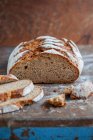 Um longo pedaço de pão integral de massa azeda, fatiado — Fotografia de Stock