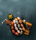 Saucisses espagnoles sur la planche à découper (butifarra blanca, chorizo, morcilla de cebolla) — Photo de stock