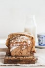 Pão de centeio em tábua de madeira com garrafa de leite — Fotografia de Stock